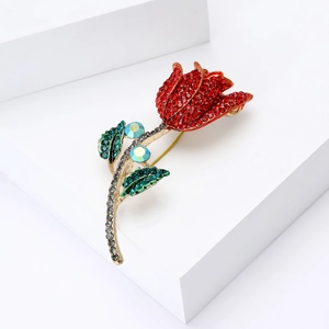 Élégante broche tulipe avec strass rouges et verts sur un support géométrique blanc