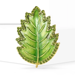 Elegant gold leaf brooch with green enamel finish and shimmering crystals decoration