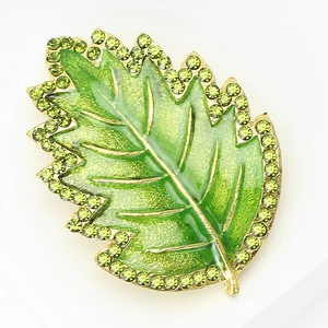 Close-up of green leaf brooch with gold metal veins and sparkling green rhinestones