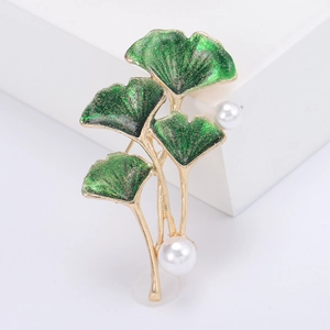 Broche élégante en feuille de ginkgo avec émail vert et perles sur fond blanc