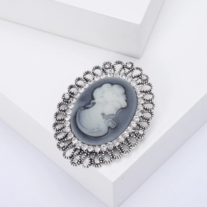 Macro shot of silver retro cameo brooch with intricate hollow metalwork and crystals
