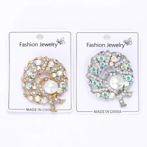 Detailed view of silver and gold round brooches with AB rhinestones and pearls