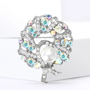Elegant silver wreath brooch with pearls and colorful crystals on white stage