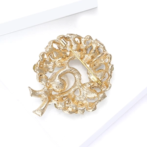 Detail of the golden metal brooch back featuring hollow carving and a secure safety pin clasp
