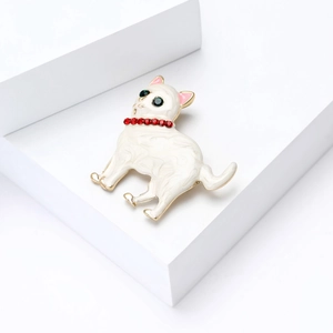 Vue détaillée de la broche chat en émail blanc avec collier de pierres rouges