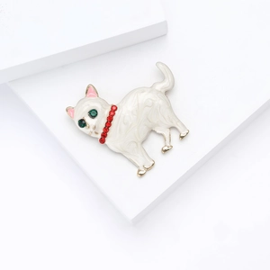 Vue détaillée de la broche chat en émail avec yeux verts et collier en strass rouge