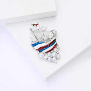 Elegant nautical sailboat brooch with white enamel sails and pearl rhinestone accents