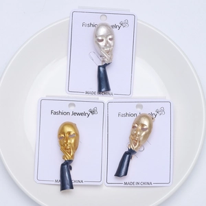 Detalle de broches de máscara de pensador con acabado esmaltado en tarjetas