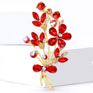 Elegant gold alloy bouquet brooch with sparkling red and AB rhinestones on a white block