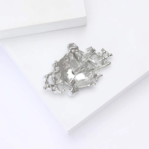 Detail view of silver alloy sailboat brooch back with metal pin and secure rotating clasp