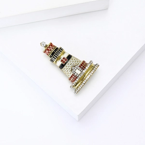 Macro detail of enamel pagoda brooch with gold plating and sparkling rhinestones