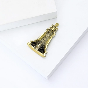 Macro view of the golden alloy brooch back featuring fine texture and pin closure mechanism