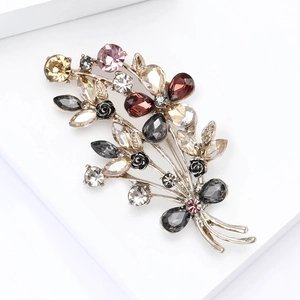 Macro shot of bouquet brooch with colorful rhinestones and black resin roses on white block