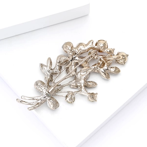Detailed back view of a gold floral brooch showing secure pin fastener and metal texture