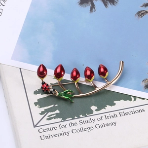 Detail view of golden branch brooch with red berries and a small enamel ladybug charm