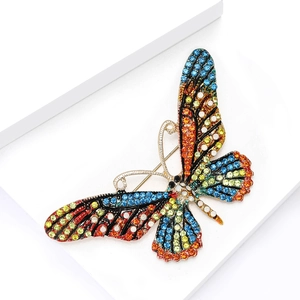 Macro detail of luxury butterfly brooch with colorful rhinestones and gold plating