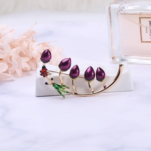 Close-up of purple enamel tulip brooch with a red ladybug on gold branches