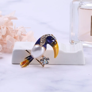 Detailed view of parrot brooch featuring blue enamel, pearl chest, and colorful rhinestones