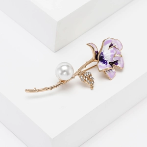 Macro detail of enamel flower brooch with rose petals, pearl and rhinestone accents