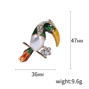 Green enamel toucan brooch with white pearl and rhinestones in gold alloy finish