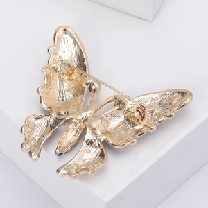 Back view of gold butterfly brooch showing the long pin clasp and textured metal surface