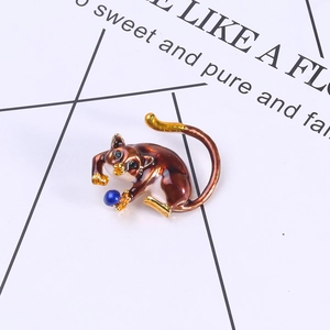 Macro shot of cute enamel cat brooch with blue bead and gold-plated alloy details