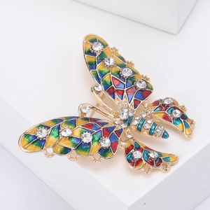 Close-up of colorful enamel butterfly brooch with sparkling crystals on gold metal base