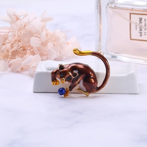 Detail of sloth animal brooch with coffee enamel and blue bead on marble base