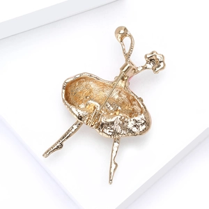 Close-up of golden ballet dancer brooch with pink enamel skirt and secure pin back clasp