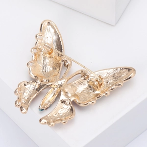 Golden butterfly brooch with blue-green accents and secure pin fastening on back