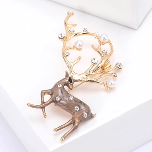 Détail d'une élégante broche cerf avec perles, strass et finition en émail chic