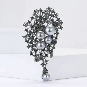 Détail macro d'une broche en alliage gris avec perles grises et strass pavés