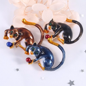 Three colorful enamel cat brooches with rhinestones on a decorative starry background