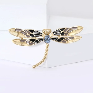 Détail de la broche libellule avec des ailes en émail coloré et strass bleus brillants