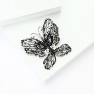 Detailed close-up of retro butterfly brooch with black and white enamel and rhinestones