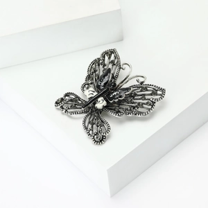 Close-up of vintage butterfly brooch with cutout wings and sparkling rhinestones
