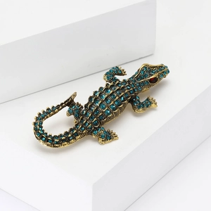 Vintage gold crocodile brooch with sparkling blue rhinestones and red crystal eye