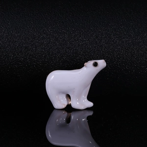 Macro detail of cute white polar bear enamel pin with smooth polished finish on dark texture