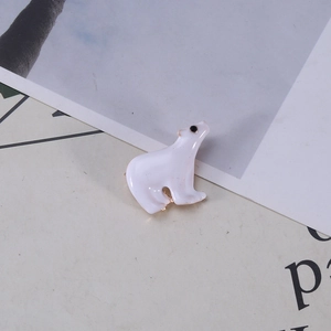 Close-up of cute white polar bear enamel brooch with gold-tone plating details
