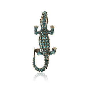 Crocodile brooch in gold metal with blue crystals and red rhinestone eyes detail