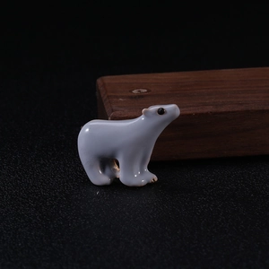 Detailed close-up of a cute polar bear enamel brooch pin with a grey metallic finish