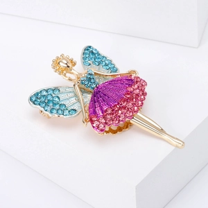 Dettaglio di una spilla a ballerina dorata con strass blu, viola e rosa acceso