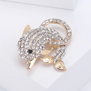 Detail of dolphin brooch with white rhinestones on golden plated alloy material