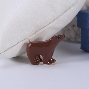 Close-up of brown enamel animal brooch with gold-tone metal base and small black stone