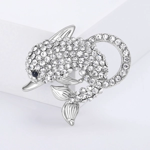 Macro detail of silver dolphin brooch with hand-set sparkling white rhinestones