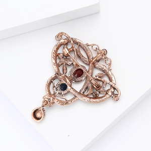 Detailed back view of vintage bronze brooch showing pin clasp and gemstone settings