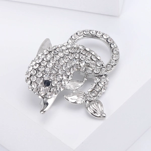 Close-up of a silver dolphin brooch with full pavé crystals and a black gemstone eye