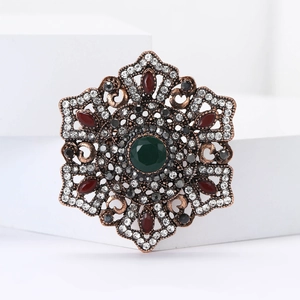 Baroque style hexagon brooch with green center stone and red crystals on bronze base