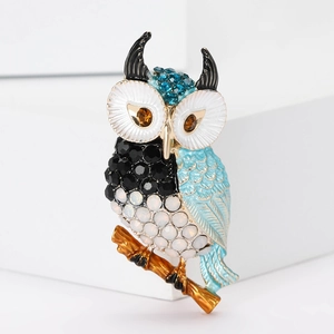 Detailed view of alloy owl brooch featuring colorful rhinestones and enamel on a branch