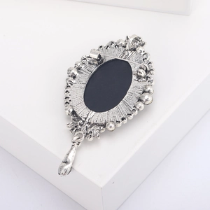 Detail of vintage silver relief brooch back featuring safety pin and pendant loop hook